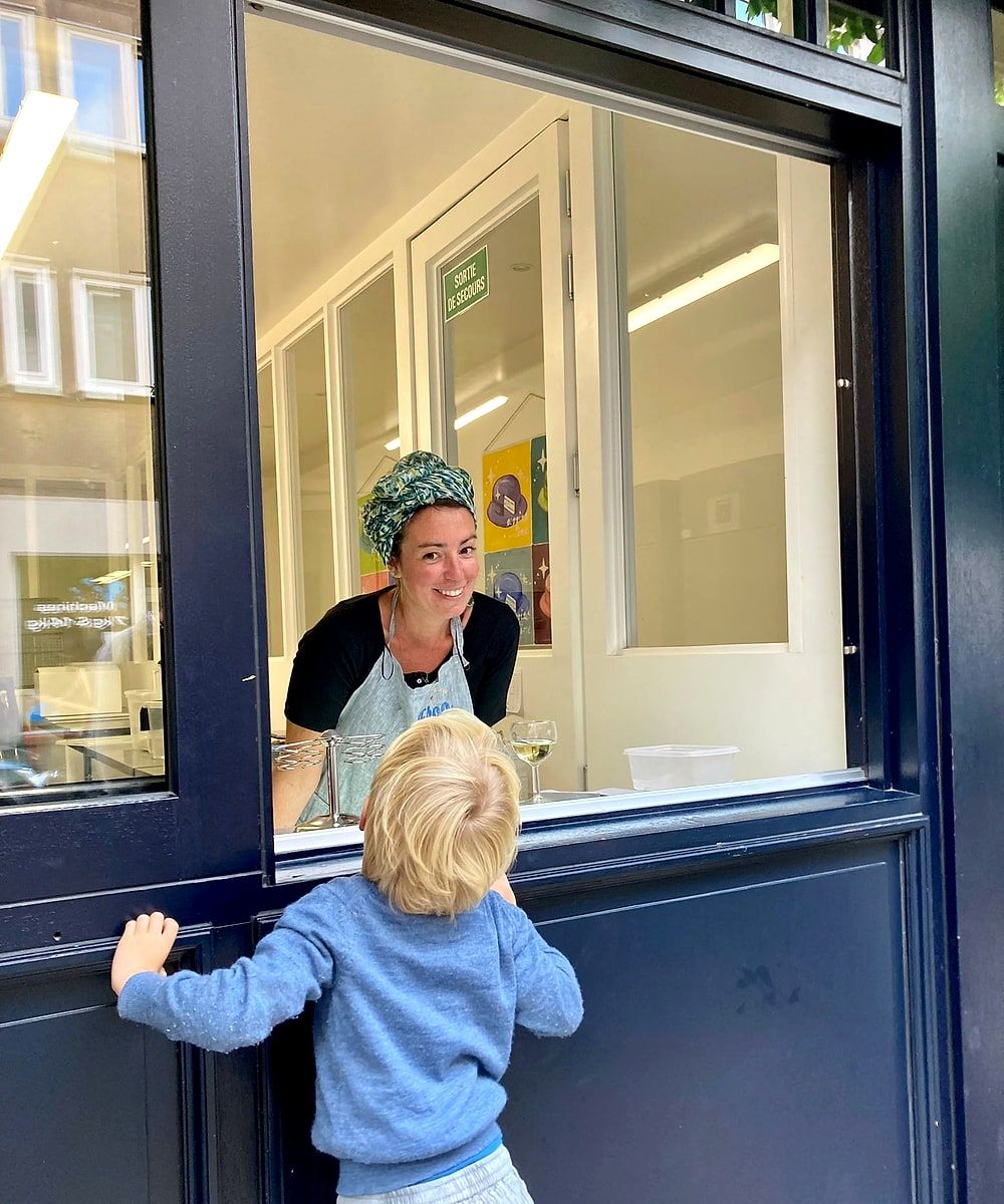 Frédérique Vanhorenbeek accueille un enfant au comptoir ouvert sur la rue, atelier Froo Icecream rue Middelbourg